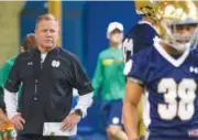  ?? ASSOCIATED PRESS FILE PHOTO ?? Notre Dame football coach Brian Kelly, left, runs drills during a spring practice at the Loftus Sports Center in South Bend, Ind. Kelly is doing some things differentl­y this spring. He feels he has to after a 4-8 season that in many ways was a disaster...