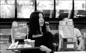  ?? REUTERS ?? A woman carries a tray of food inside a KFC restaurant in Beijing. Yum Brands Inc, the parent company of KFC, has seen its China sales slide.