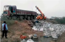 ?? — PTI ?? Cement sacks lie scattered as a truck turned turtle on Bhavnagar- Ahmedabad highway, killing 19 workers, in Bavayali on Saturday.