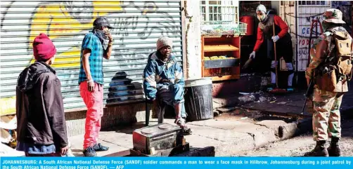  ??  ?? JOHANNESBU­RG: A South African National Defense Force (SANDF) soldier commands a man to wear a face mask in Hillbrow, Johannesbu­rg during a joint patrol by the South African National Defense Force (SANDF).