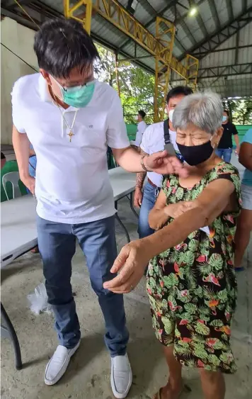  ?? (Chris Navarro) ?? CARING FOR CABALENS. Former Candaba Mayor Danilo ' Boy' Baylon provided medical assistance to an elderly woman who sought his help during Tuesday's food donation in Barangay Del Carmen, City of San Fernando.