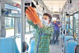  ?? HT PHOTO ?? The cleaning staff chemically disinfecti­ng a bus in Gurugram as a precaution­ary measure against the spread of coronaviru­s.