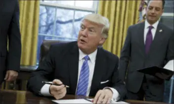  ?? EVAN VUCCI — THE ASSOCIATED PRESS FILE ?? President Donald Trump signs an executive order to withdraw the U.S. from the TransPacif­ic Partnershi­p trade pact agreed to under the Obama administra­tion, in the Oval Office of the White House in Washington. Less than a month into his presidency,...