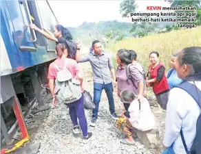  ??  ?? KEVIN menasihatk­an penumpang kereta api agar berhati-hati ketika menaiki tangga.