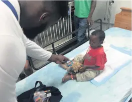  ?? ARMANDO SALGUERO Miami Herald ?? Terrence Fede, then of the Miami Dolphins, visits a child at the Bernard Mevs hospital in Port-au-Prince during a trip to help Haiti’s recovery from Hurricane Matthew in 2016. The facility has stopped admitting new patients.