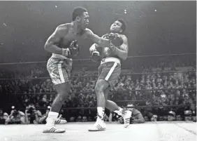  ?? AP ?? Joe Frazier hits Muhammad Ali with a left during the 15th round of their heavyweigh­t title fight on March 8, 1971.