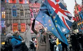  ?? FRANCISCO SECO/AP ?? A woman holds up the Union and the European Union flags at an event called “Brussels calling” to celebrate the friendship between Belgium and Britain on Thursday in Brussels.