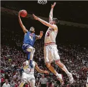  ?? AJ Mast / Associated Press ?? Houston Baptist’s Braxton Bonds, left, goes up for a shot as Indiana’s Zach McRoberts moves in to defend in the first half of Saturday’s game.