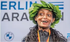  ?? ?? Ethiopian runner Tigist Assefa celebrates achieving a new women's world record of 2 hours, 11 minutes and 53 seconds in the Berlin marathon. Photograph: Luciano Lima/Getty Images