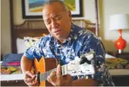  ?? AP PHOTO/MENGSHIN LIN ?? On Oct. 10, Charles Nahale plays the only guitar he took with him from the wildfire at a hotel in Lahaina, Hawaii.