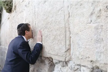  ?? (Marc Israel Sellem/The Jerusalem Post) ?? INCOMING PRESIDENT Isaac Herzog kisses the Western Wall on the eve of his swearing-in last night.