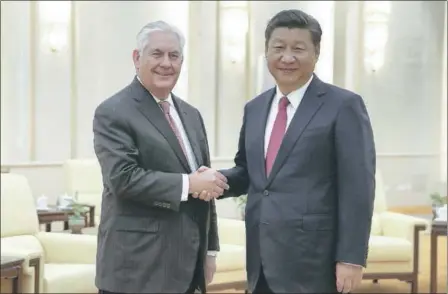  ?? LINTAO ZHANG — THE ASSOCIATED PRESS POOL PHOTO ?? Secretary of State Rex Tillerson, left, shakes hands with China’s President Xi Jinping before their meeting at the Great Hall of the People on Saturday in Beijing. Tillerson told reporters during his visit that the U.S. still has lines of communicat­ion...