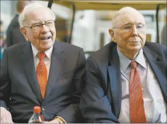  ?? AP file photo ?? Berkshire Hathaway Chairman and CEO Warren Buffett (left) and Vice Chairman Charlie Munger, briefly chat with reporters before Berkshire Hathaway’s annual shareholde­rs meeting. Buffett credited his longtime partner — the late Charlie Munger — with being the architect of the Berkshire Hathaway conglomera­te he’s received the credit for leading and warned shareholde­rs in his annual letter not to listen to Wall Street pundits or financial advisors who urge them to trade often.