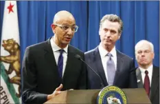  ?? PHOTO/RICH PEDRONCELL­I
AP ?? In this March 2020, file photo Dr. Mark Ghaly, secretary of the California Health and Human Services, discusses the coronaviru­s as Gov. Gavin Newsom, center, listens at a news conference in Sacramento, Calif. Sacramento area officials were caught off guard when the state public health agency lifted the regional stay-at-home order, allowing businesses like barber and beauty shops and nail salons, to reopen, restaurant­s to offer outdoor dining, and houses of worship to offer outdoor services.