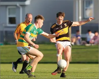 ??  ?? Buttevant’s Sean Madigan gets a pass away as he is closed down by Ballycloug­h’s Peter Carroll during last weekend’s Synergy Fermoy Credit Union JAFC Semi-Final in Churchtown Photo by Eric Barry