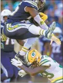  ?? Robert Gauthier Los Angeles Times By Jeff Miller ?? CHARGERS RUNNING BACK Melvin Gordon hurdles Green Bay’s Chandon Sullivan for a 16-yard gain.