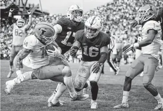  ?? Scott Taetsch / Getty Images ?? Illinois’ Casey Washington catches the winning 2-point conversion pass in the ninth overtime to beat No. 7 Penn State in State College, Pa. It was the first nine-overtime game in NCAA history.