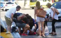  ?? The Associated Press ?? A person is treated in Barcelona on Thursday after a white van jumped the sidewalk in the historic Las Ramblas district, crashing into a summer crowd of residents and tourists. Police said 13 people were killed and 100 were injured.