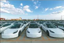  ?? WANG XIANG / XINHUA ?? Tesla Inc’s Model 3 electric vehicles, produced in Shanghai, are ready for export to Europe.