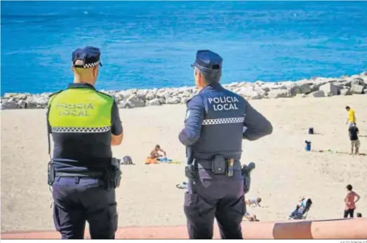  ?? JULIO GONZÁLEZ ?? Agentes de la Policía Local de Cádiz vigilan la playa de Santa María del Mar.
