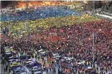  ??  ?? VADIM GHIRDA, AP People light mobile phones in the colors of Romania’s flag during a protest in Bucharest Sunday. Protesters want the government to resign after it passed a decree that would have diluted the anti-corruption fight that has targeted top...