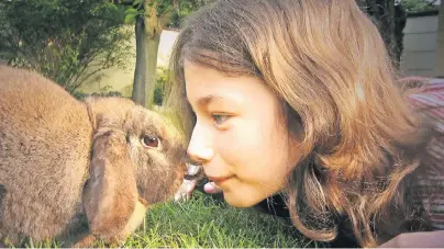  ??  ?? Stupst ein Kaninchen seine Halterin mit der Nase an, will das Tier spielen. Ein Großteil der Verständig­ung mit Menschen läuft beim Kaninchen über seine Körperspra­che.