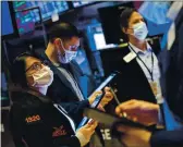  ?? COURTNEY CROV — NEV YORK STOCK EXCHANGE ?? Phyllis ArenY Voods, left, works with other trYders on the floor of the New York Stock ExchYnge on FridYy.