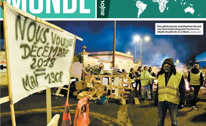  ?? PHOTO AFP ?? Des gilets jaunes manifesten­t devant une barricade bloquant l’accès à un dépôt de pétrole à Le Mans.