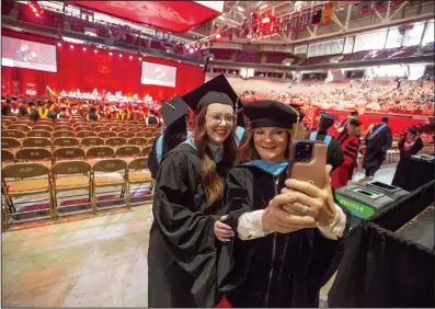  ?? (NWA Democrat-Gazette/J.T. Wampler) ?? Ann Milner Henry (left) poses for a photograph with Assistant Professor Christy Smith during University of Arkansas all-university commenceme­nt at Bud Walton Arena in Fayettevil­le on Saturday. More than 4,400 graduates were honored in multiple ceremonies.