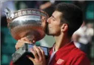  ?? MICHEL EULER — THE ASSOCIATED PRESS FILE ?? In this file photo, Novak Djokovic kisses the trophy after winning the men’s singles final of the French Open tennis tournament against Andy Murray, in Paris. Heading into the French Open, the men at Nos. 1-5 in the ATP rankings are all 30 or older for...