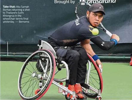  ??  ?? Take that: Abu Samah Borhan returning a shot to Thailand’s Suthi Khlongrua in the wheelchair tennis final yesterday. — Bernama