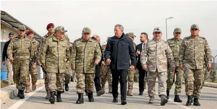  ?? AP ?? Turkey’s National Defence Minister Hulusi Akar, center, and Turkish army’s top commanders arrive to inspect troops at the border with Syria, in Hatay, Turkey.