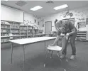  ?? LM OTERO/AP ?? Maria Concha wipes down a chair at a school in Texas. Parents are weighing whether to enroll their kids in online or in-person instructio­n.