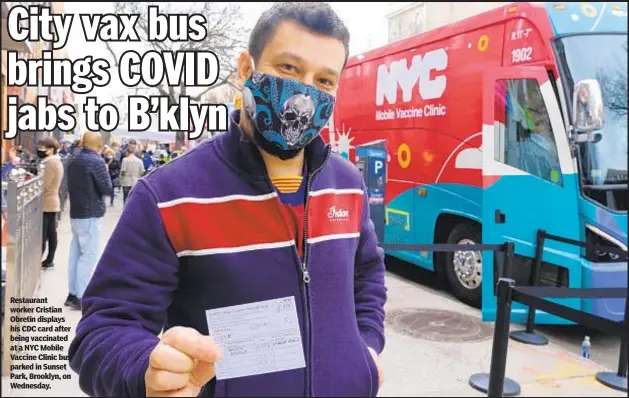  ??  ?? Restaurant worker Cristian Obretin displays his CDC card after being vaccinated at a NYC Mobile Vaccine Clinic bus parked in Sunset Park, Brooklyn, on Wednesday.