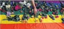  ?? REUTERS ?? Campaigner­s place flowers on a multicolou­red flag as they protest for LGBT rights in Chechnya outside the Russian embassy in London, in a file photo.