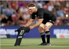  ??  ?? All Blacks captain Sam Cane lays down a No 10 jersey in memory of Diego Maradona prior to the Tri-Nations match against the Pumas in Newcastle on Saturday night.