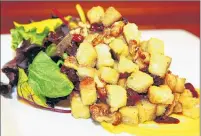  ??  ?? The Brown Bottle’s riff on the summery Tuscan panzanella salad for winter includes butternut squash puree under mixed greens with cranberrie­s, walnuts and croutons with roasted-shallot vinaigrett­e.