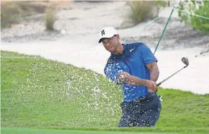  ??  ?? Tiger Woods hits out of a bunker on the ninth hole during Monday’s practice round for the Hero World Challenge golf tournament. KYLE TERADA/USA TODAY SPORTS