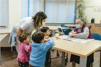  ?? ELISABETTA ZAVOLI/THE NEW YORK TIMES 2022 ?? Toddlers visit with a woman in an elder care facility in Piacenza, Italy. The country’s elderly population is soaring as the birthrate plummets, but Premier Georgia Meloni’s government is working to change that.