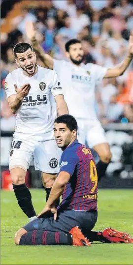  ?? BIEL ALIÑO / EFE ?? Gayá le pide a Luis Suárez que se levante, el domingo en Mestalla