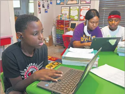  ?? CHRISTOPHE­R MILLETTE — ERIE TIMES-NEWS VIA AP ?? From left: Michael Henry, 11; his mother Mary Euell, 30; and his brother Mario Henry, 12, work through math lessons remotely at their west Erie, Pa., home, Tuesday, Sept. 8, 2020, on the first day of classes for the Erie School District. Most of the district’s 11,000 students are beginning the school year with remote learning, to slow the spread of COVID-19, the new coronaviru­s.