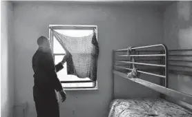  ?? KIM HAIRSTON/BALTIMORE SUN ?? Anthony Scott, Baltimore housing authority deputy executive director, looks out a secondfloo­r window of an apartment in McCulloh Homes in 2018.