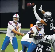  ?? ETHAN MILLER — GETTY IMAGES, FILE ?? Bills quarterbac­k Josh Allen completes a pass as Raiders defensive end Maxx Crosby defends during the first half of their Oct. 4 game at Allegiant Stadium in Las Vegas.