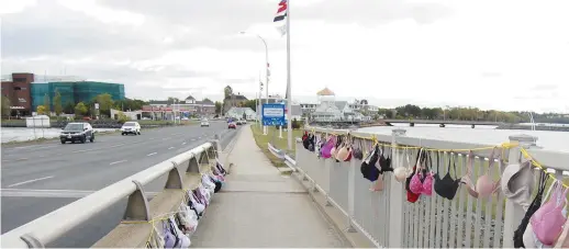 ??  ?? Plusieurs centaines de soutiens-gorge ont été accrochés sur le pont principal de Bathurst pour sensibilis­er la population à la cause du cancer du sein. - Acadie Nouvelle: Béatrice Seymour