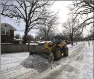  ?? (Arkansas Democrat-Gazette/Staton Breidentha­l) ?? North Little Rock Street Department personnel use heavy machinery Tuesday to clear snow off Idlewild Ave.