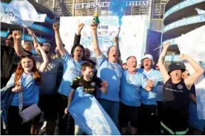  ?? AFP/VNA Photo ?? SINGING THE BLUES: Manchester City fans celebrate outside of the Etihad Stadium after winning the Premier League.