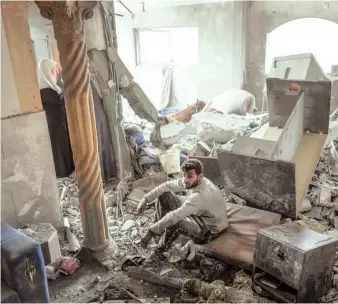  ?? — AFP ?? A Palestinia­n inspects the rubble in a house, following Israeli bombardmen­t, in the Maghazi camp for Palestinia­n refugees in the central Gaza Strip on Friday.