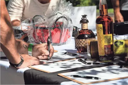  ?? NICOLAS GALINDO/THE COLUMBUS DISPATCH ?? A bid is placed on a prize of bourbon during a silent auction at the Drill 4 Life event at Highbanks Metro Park on Sunday.