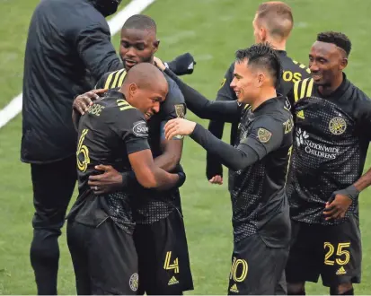  ?? ADAM CAIRNS/COLUMBUS DISPATCH ?? Darlington Nagbe (6) hugs Jonathan Mensah as Lucas Zelarayan (10) and Harrison Afful (25) join the celebratio­n of Nagbe’s goal early in the second half.