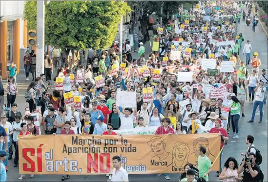  ?? Ulises Ruiz AFP/Getty Images ?? PEOPLE take part in a protest over the disappeara­nce of three film students who went missing last week in the Guadalajar­a suburb of Tonala in Mexico’s Jalisco state.